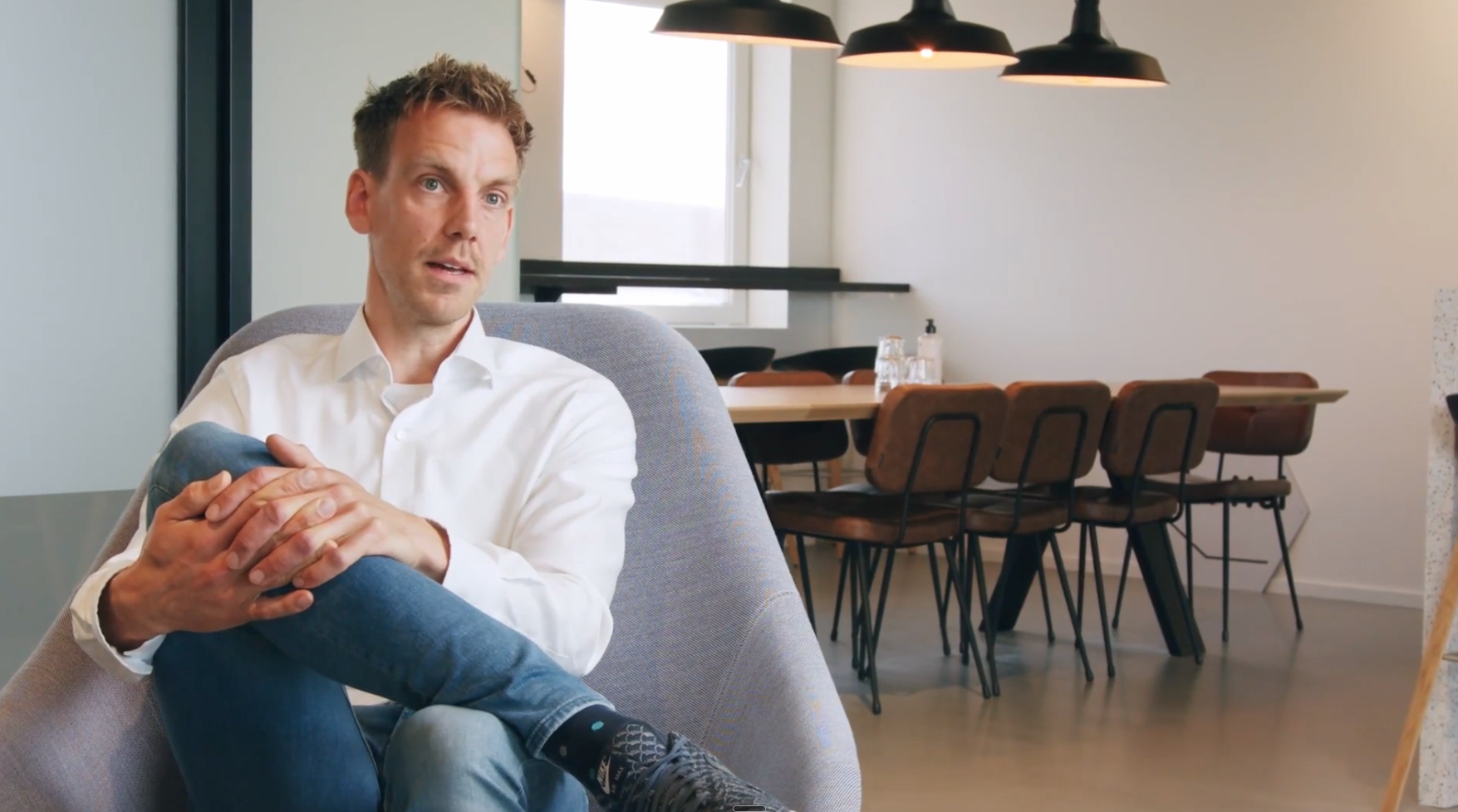 Ron de Kroon, Business Development Manager at Shuttel, speaking during a video interview in a modern office space.